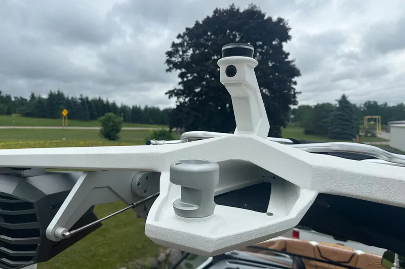 Slide: The Image of 2025 Nautique Super Air Nautique G23 boat tower against cloudy sky and trees. - 17