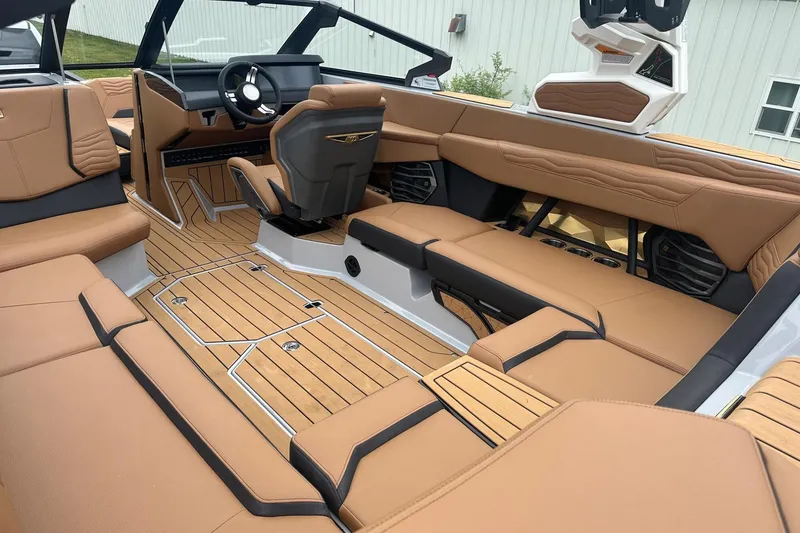 Slide: The Image of 2025 Nautique Super Air Nautique G23 interior with luxurious tan seating and sleek design. - 18