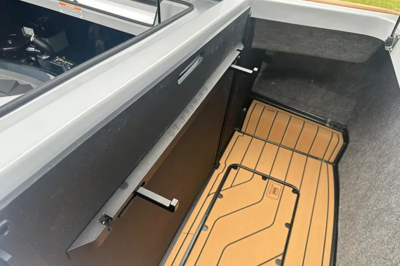 Slide: The Image of 2025 Nautique Super Air Nautique G23 interior storage compartment with sleek design and flooring. - 20