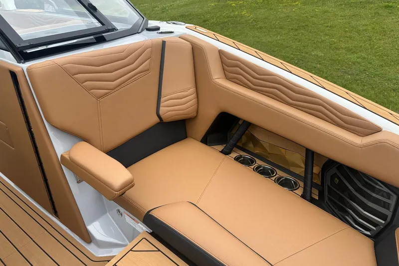 Slide: The Image of 2025 Nautique Super Air Nautique G23 interior with tan leather seating and cup holders. - 27