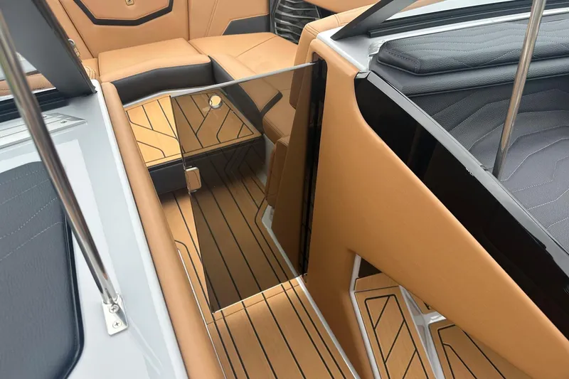 Slide: The Image of 2025 Nautique Super Air Nautique G23 interior with tan and black seating, sleek design. - 32