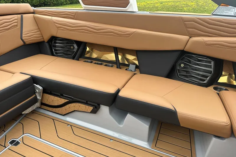 Slide: The Image of 2025 Nautique Super Air Nautique G23 interior with tan leather seating and premium speakers. - 35