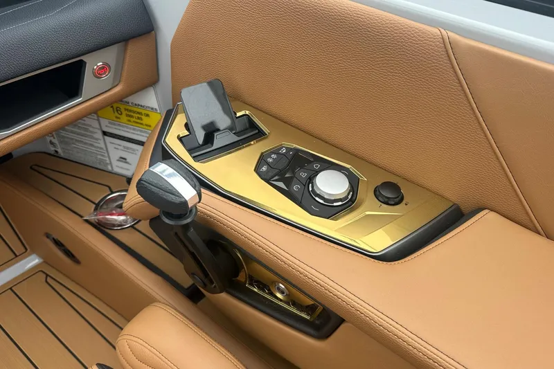 Slide: The Image of 2025 Nautique Super Air Nautique G23 control panel with tan leather and gold accents. - 39