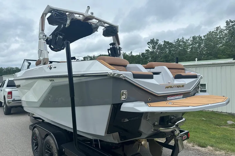 Slide: The Image of 2025 Nautique Super Air Nautique G23 boat on trailer, rear view, outdoors. - 4