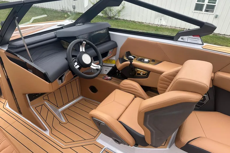 Slide: The Image of 2025 Nautique Super Air Nautique G23 interior with tan leather seats and modern dashboard. - 8