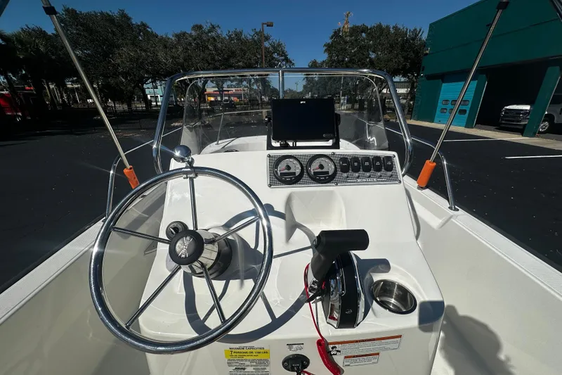 Slide: The Image of 2022 Boston Whaler 170 Montauk boat dashboard with steering wheel and controls. - 7