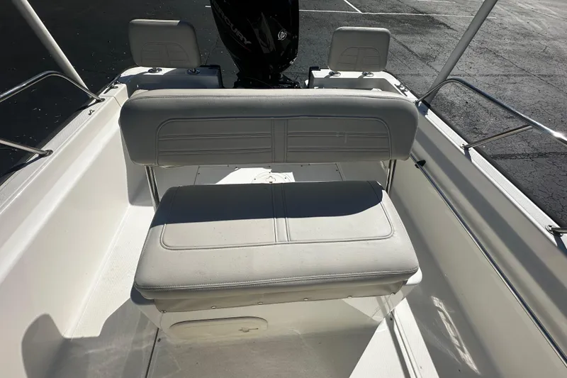 Slide: The Image of 2022 Boston Whaler 170 Montauk boat interior with cushioned seating and railing. - 9