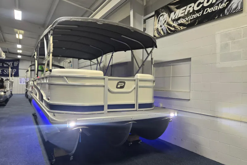 The Image of 2025 Princecraft Vectra 23 RL pontoon boat displayed indoors with canopy and blue lighting. - 0