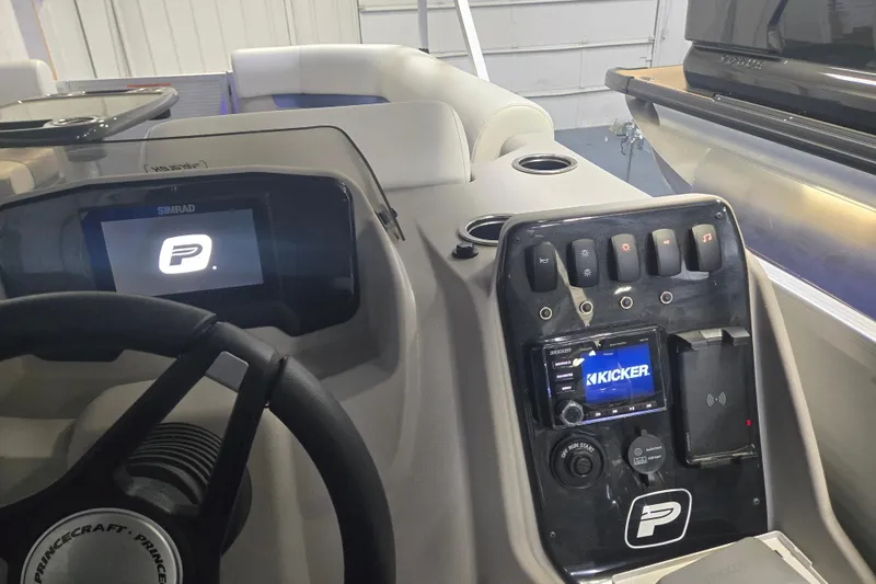 Slide: The Image of 2025 Princecraft Vectra 23 RL dashboard with Simrad display and Kicker audio system. - 2