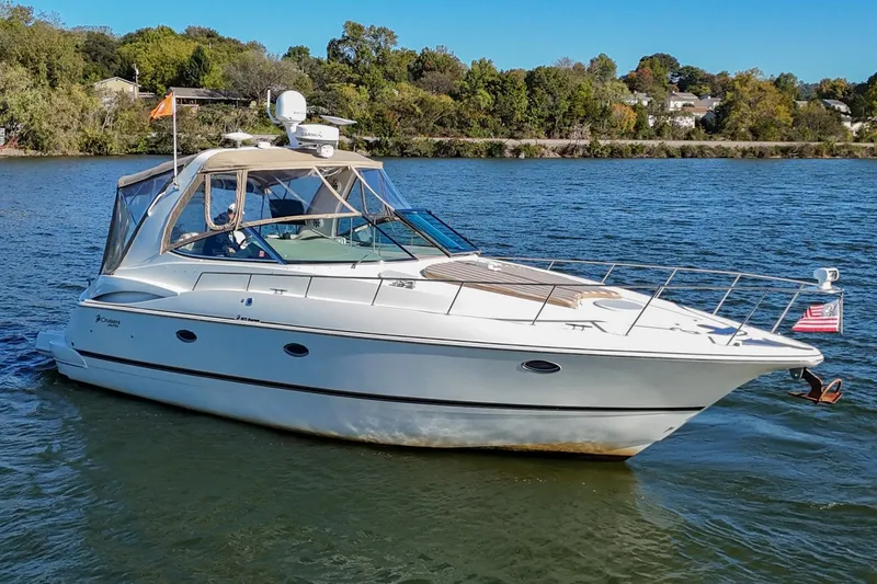 The Image of 2001 Cruisers Yachts 3672 Express on a serene lake with lush green shoreline. - 0