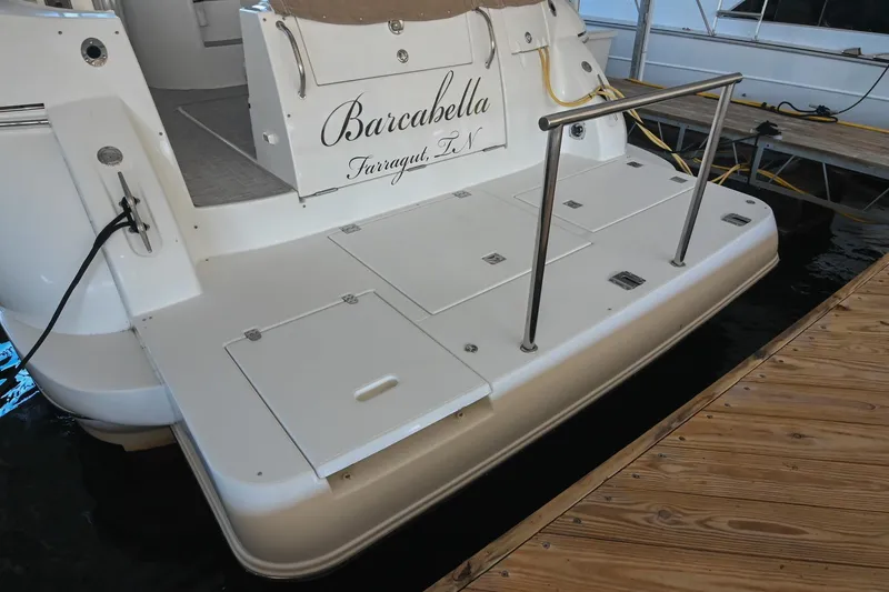 Slide: The Image of 2001 Cruisers Yachts 3672 Express docked, featuring spacious swim platform and elegant design. - 10