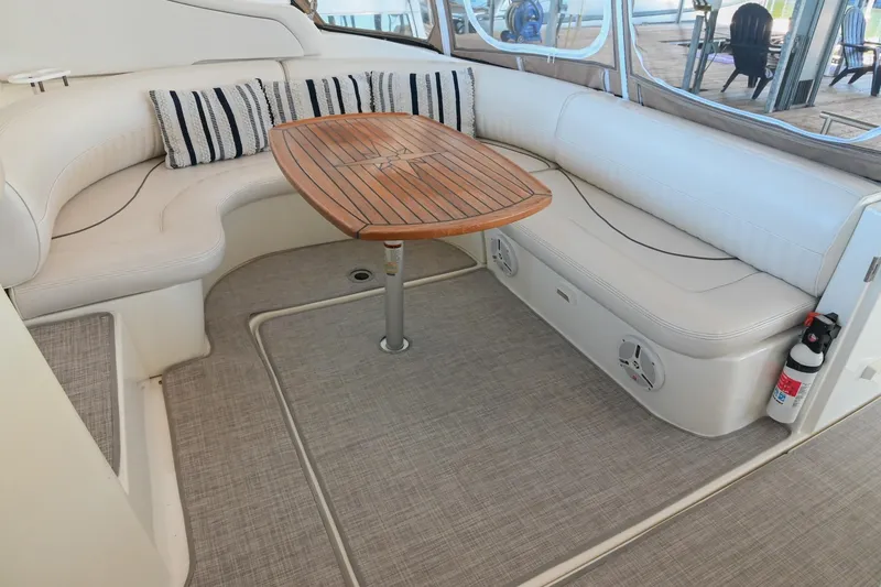 Slide: The Image of 2001 Cruisers Yachts 3672 Express interior with white seating and wooden table. - 13