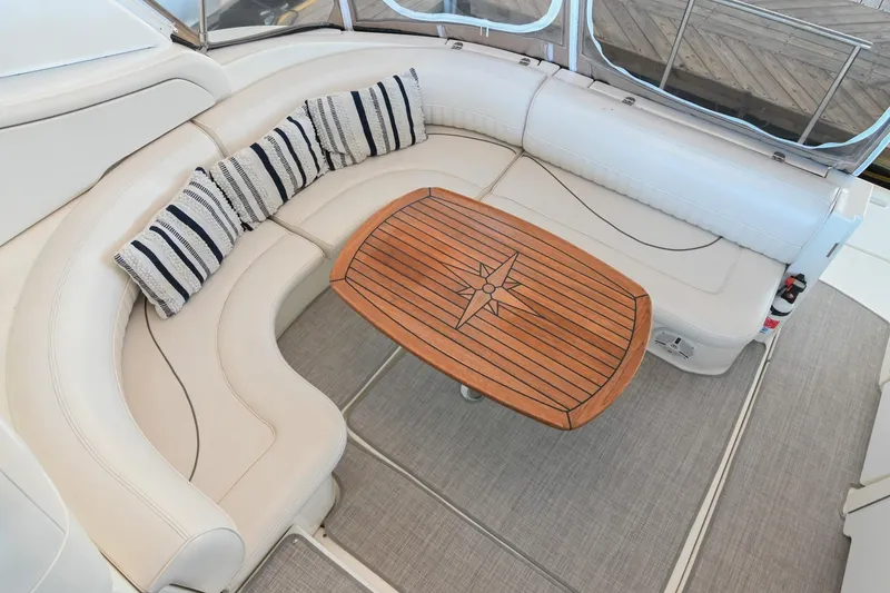 Slide: The Image of Luxurious seating area on 2001 Cruisers Yachts 3672 Express with wooden table and striped cushions. - 14