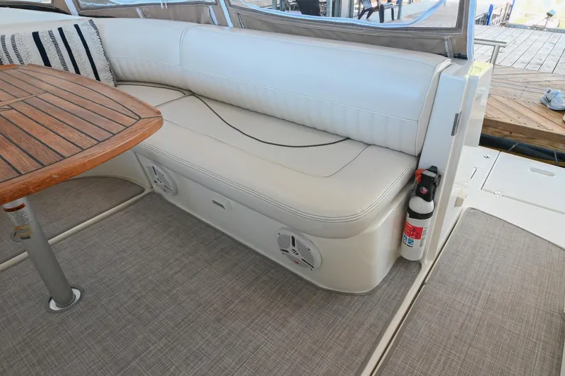 Slide: The Image of 2001 Cruisers Yachts 3672 Express interior with white seating and wooden table. - 15
