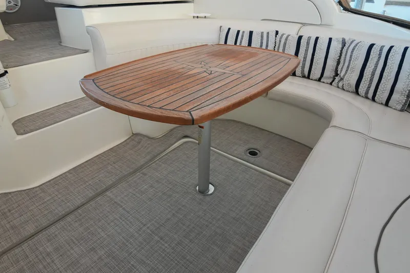 Slide: The Image of 2001 Cruisers Yachts 3672 Express interior with wooden table and cushioned seating. - 17