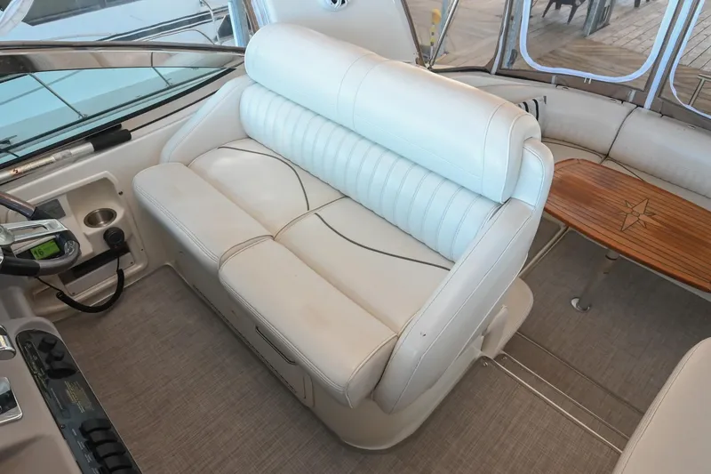 Slide: The Image of 2001 Cruisers Yachts 3672 Express interior with white leather seating and wooden table. - 32