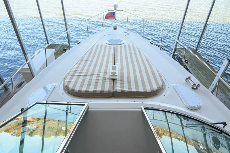 Slide: The Image of 2001 Cruisers Yachts 3672 Express boat deck with striped sun pad and American flag. - 34