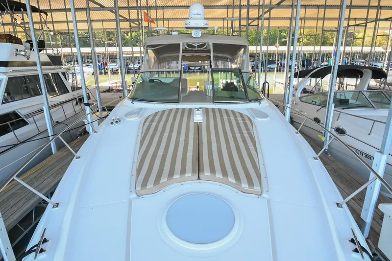 Slide: The Image of 2001 Cruisers Yachts 3672 Express docked, featuring spacious deck and striped sunbed. - 35
