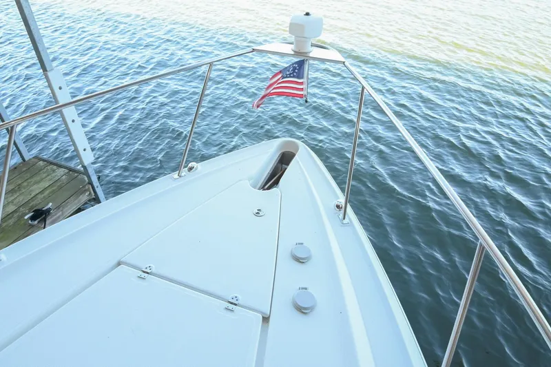 Slide: The Image of Bow view of 2001 Cruisers Yachts 3672 Express with American flag on calm water. - 37