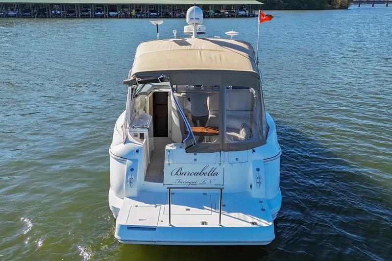 Slide: The Image of 2001 Cruisers Yachts 3672 Express on water, rear view with canopy and flag. - 4