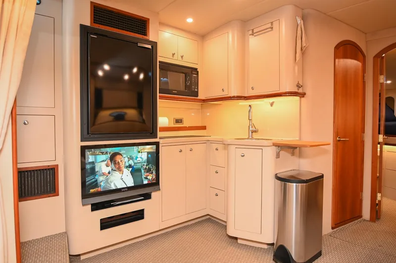 Slide: The Image of 2001 Cruisers Yachts 3672 Express interior with kitchenette, TV, and modern amenities. - 43