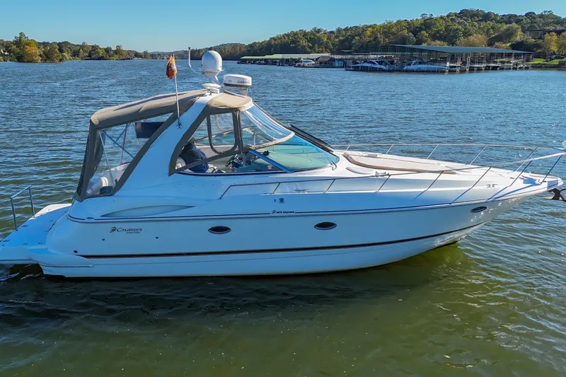 Slide: The Image of 2001 Cruisers Yachts 3672 Express on a serene lake with lush green surroundings. - 5