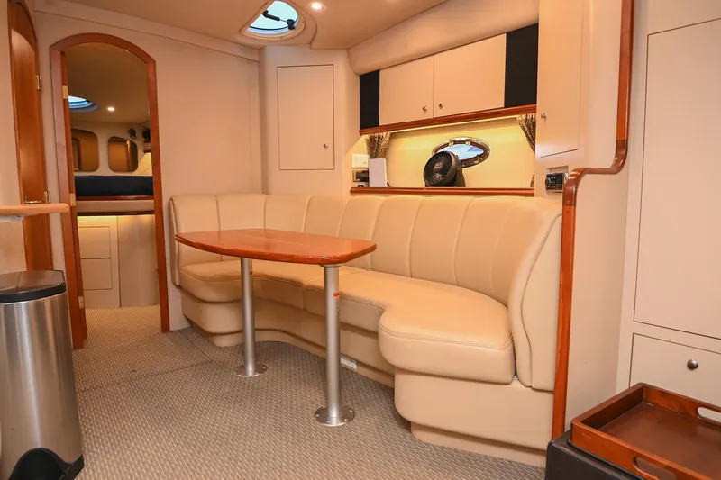 Slide: The Image of 2001 Cruisers Yachts 3672 Express interior with beige seating and wooden table. - 50