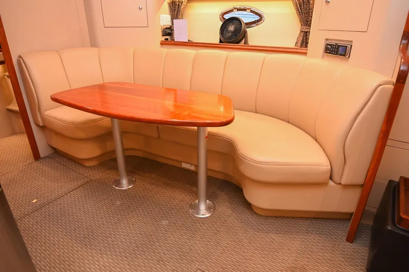 Slide: The Image of 2001 Cruisers Yachts 3672 Express interior with beige seating and wooden table. - 52