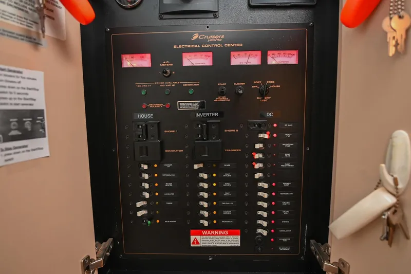 Slide: The Image of Electrical control panel of 2001 Cruisers Yachts 3672 Express, featuring various switches and meters. - 53