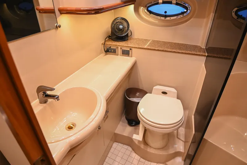 Slide: The Image of Luxurious bathroom in 2001 Cruisers Yachts 3672 Express with sink, toilet, and porthole window. - 57