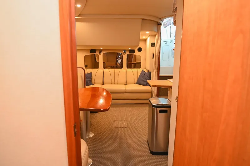Slide: The Image of Interior of 2001 Cruisers Yachts 3672 Express, featuring a cozy seating area and wooden accents. - 62