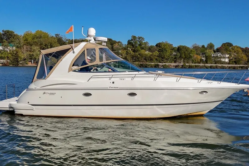 Slide: The Image of 2001 Cruisers Yachts 3672 Express on a serene lake with clear blue skies. - 7