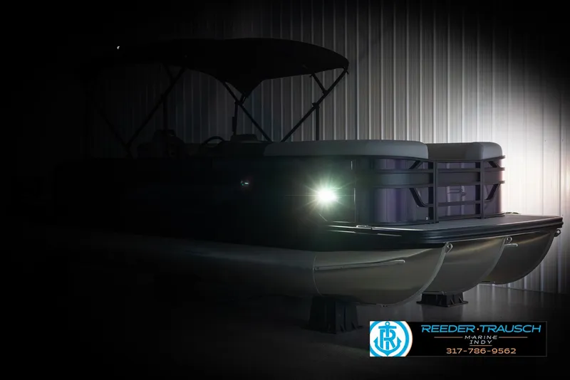 Slide: The Image of 2025 Bennington 21 SSB pontoon boat with illuminated headlight in a dimly lit setting. - 4