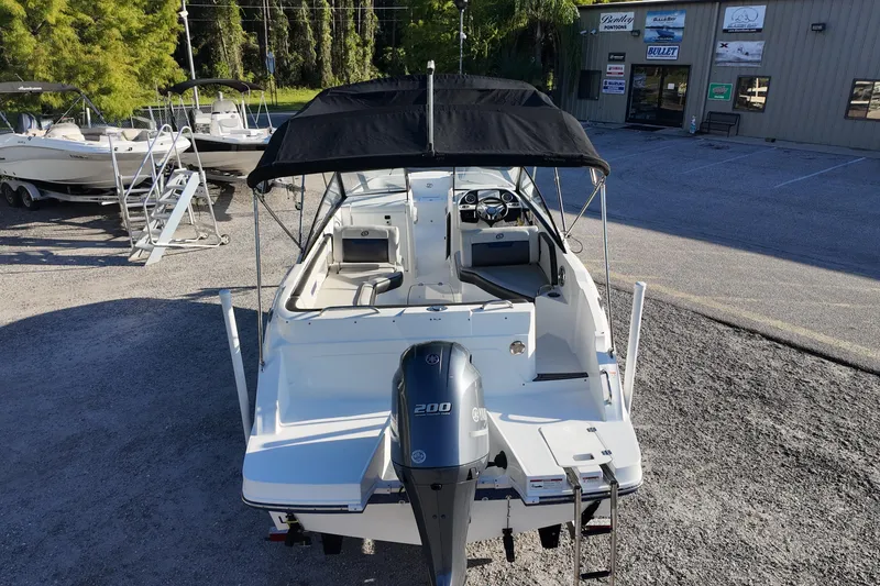 Slide: The Image of 2022 Hurricane SunDeck 235 OB boat with Yamaha engine, parked outdoors. - 11
