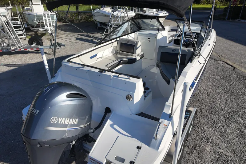 Slide: The Image of 2022 Hurricane SunDeck 235 OB boat with Yamaha engine, docked outdoors. - 12