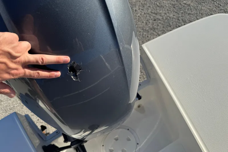 Slide: The Image of Damaged 2022 Hurricane SunDeck 235 OB outboard motor with visible hole. - 29
