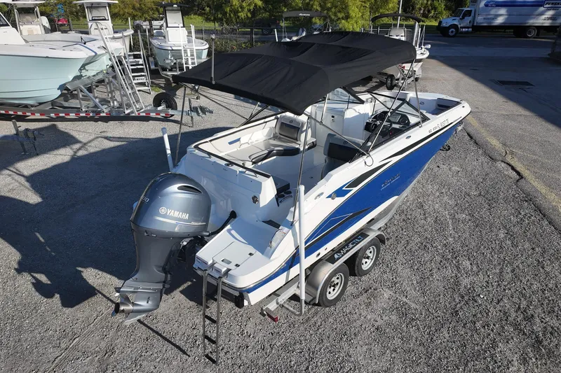 Slide: The Image of 2022 Hurricane SunDeck 235 OB boat with Yamaha outboard motor, parked on trailer. - 9