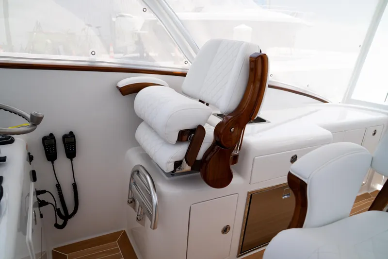 Slide: The Image of Luxurious helm seating on 2026 Front Runner 47WA boat, featuring white upholstery and wood accents. - 13