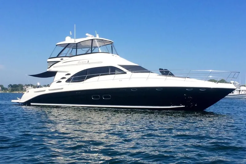 The Image of 2007 Sea Ray 580 Sedan Bridge yacht on calm water under clear blue sky. - 0