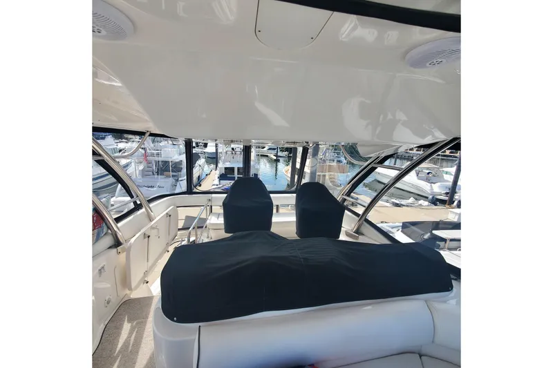Slide: The Image of 2007 Sea Ray 580 Sedan Bridge interior with covered seating and marina view. - 13