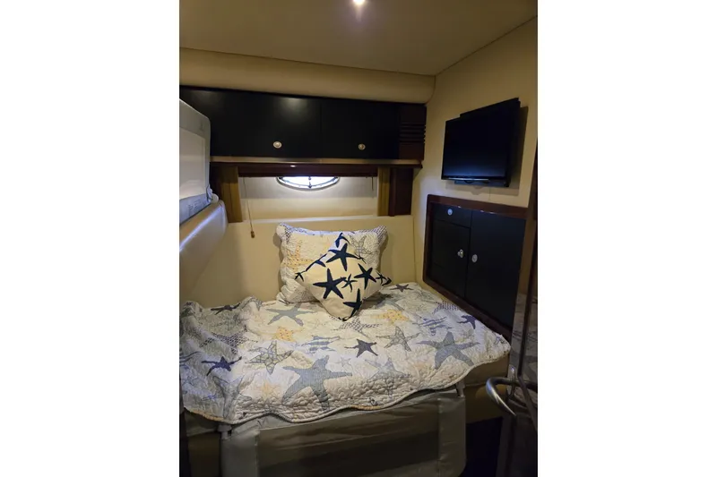 Slide: The Image of Cozy cabin interior of 2007 Sea Ray 580 Sedan Bridge with starfish-themed bedding. - 22