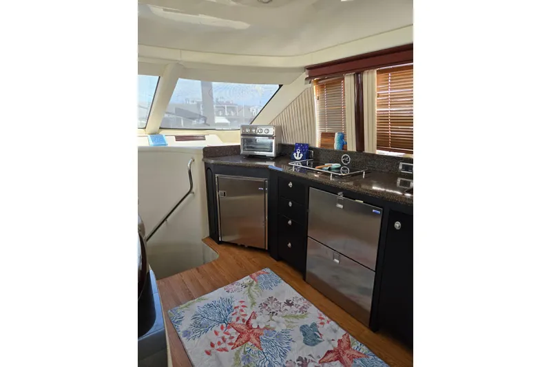 Slide: The Image of Interior of 2007 Sea Ray 580 Sedan Bridge with modern kitchen and nautical decor. - 25