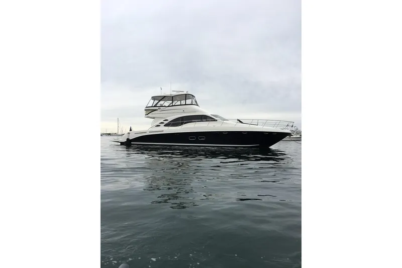 Slide: The Image of 2007 Sea Ray 580 Sedan Bridge yacht on calm water under cloudy sky. - 3