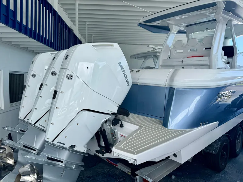 Slide: The Image of 2025 Intrepid 41 Panacea boat with triple Mercury outboard engines in a covered storage area. - 1