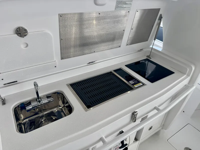 Slide: The Image of Outdoor kitchen on 2025 Intrepid 41 Panacea boat with sink, grill, and stove. - 11