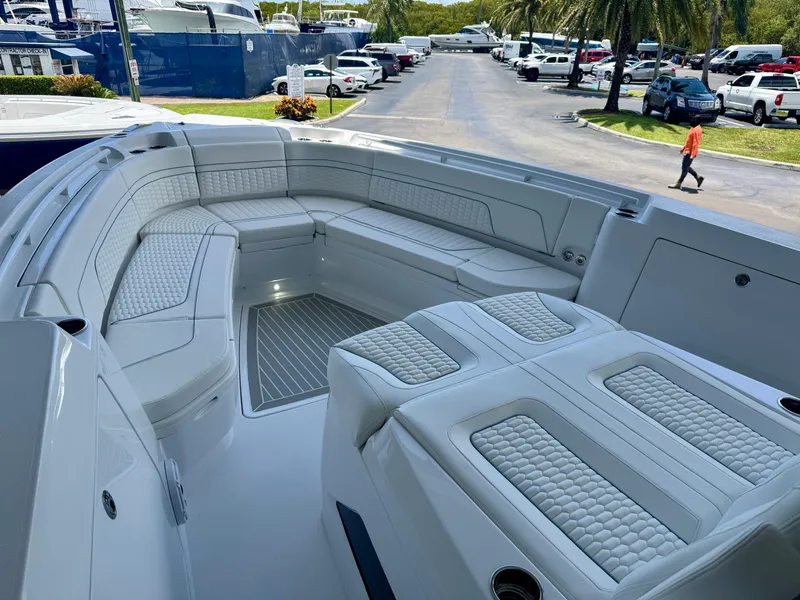 Slide: The Image of Luxurious seating area on 2025 Intrepid 41 Panacea boat, docked with palm trees in background. - 9