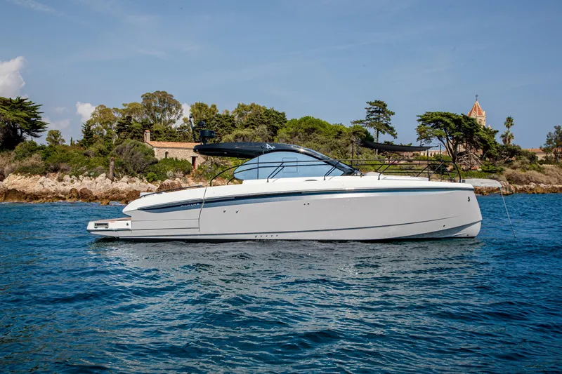 Slide: The Image of 2026 Beneteau Gran Turismo 40 yacht on serene blue waters near a lush coastline. - 10