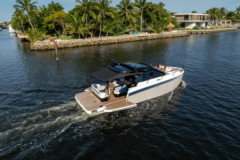 Slide: The Image of 2026 Beneteau Gran Turismo 40 yacht cruising on a scenic waterway with lush greenery. - 32