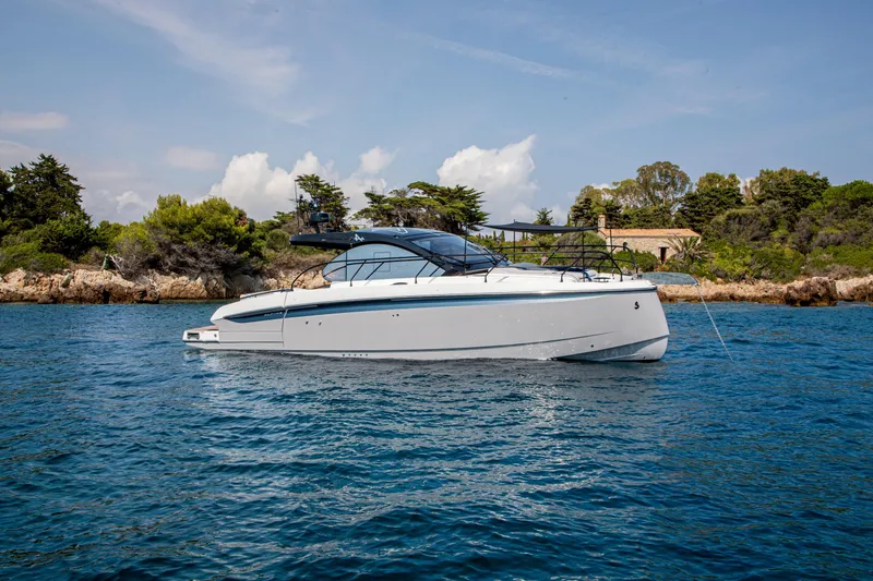 Slide: The Image of 2026 Beneteau Gran Turismo 40 yacht cruising near a scenic coastline. - 9