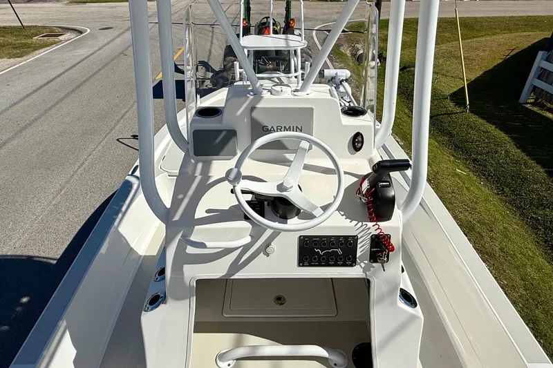 Slide: The Image of 2024 Shallow Sport 24 Modified V boat with Garmin navigation system, steering wheel, and control panel. - 10